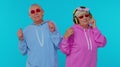 Senior stylish grandparents pensioners listening music via headphones, dancing disco fooling around Royalty Free Stock Photo