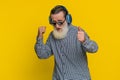 Senior stylish old man listening music via headphones and dancing, happy grandfather pensioner Royalty Free Stock Photo