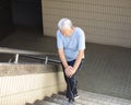 senior Suffering from knee Pain on stair