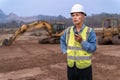 Senior supervisor construction engineer in his work cloths communicating with his working staff through walkie talkie radio at