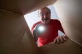 Senior surprised man unpacking, opening carton box and looking inside. Royalty Free Stock Photo