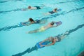 Senior swimmers with instructor swimming in pool