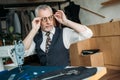 senior tailor wearing glasses for sewing