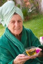 A senior takes a cup of tisane in an open spa studio