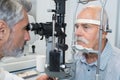Senior taking eye test examination at opticians