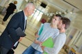 Senior teacher discussing with students in university corridor Royalty Free Stock Photo