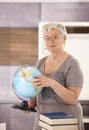 Senior teacher holding globe