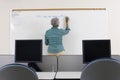 Senior Teacher Writing On Whiteboard Royalty Free Stock Photo