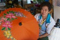 Senior Thai woman produces traditional bamboo umbrella at the factory in Chiang Mai, Thailand.