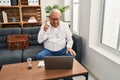 Senior therapist with grey hair doing online session at consultation office pointing finger up with successful idea Royalty Free Stock Photo