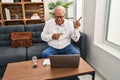 Senior therapist with grey hair doing online session at consultation office smiling and looking at the camera pointing with two Royalty Free Stock Photo