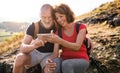 Senior tourist couple hikers in nature, taking selfie.