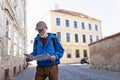 Senior tourist exploring new city, interesting places. Elderly man holding paper map, looking for the route. Solo Royalty Free Stock Photo