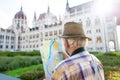 Senior tourist man watching map at Parliament, Budapest, Hungary