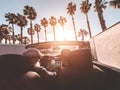 Senior trendy couple inside a convertible car on holiday time - Mature rich people having fun doing a road trip during vacation -