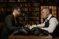 Senior versus young adult man chess battle with selective focus on boxer gloves