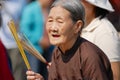 Senior Vietnamese woman prays holding incense sticks at the Buddhist temple during Chinese New Year celebration in Ho Chi Minh, V Royalty Free Stock Photo