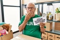 Senior volunteer man holding your donation matters covering mouth with hand, shocked and afraid for mistake