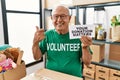 Senior volunteer man holding your donation matters smiling happy pointing with hand and finger to the side