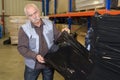 Senior warehouse worker covering pallet goods in black shrinkwrap Royalty Free Stock Photo