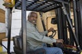 Senior Warehouse Worker Driving Forklift Royalty Free Stock Photo