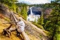 Senior watching the spectacular ice and snow cone in winter at the bottom of Helmcken Falls on the Murtle River in Wells Gray