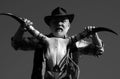 Senior western cowboy with cow skull. Old wild west man with brown jacket and hat at rodeo oudoor.