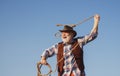 Senior western cowboy throwing lasso rope. Bearded wild west man with brown jacket and hat catching horse or cow. Rodeo Royalty Free Stock Photo