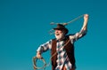 Senior western cowboy throwing lasso rope. Bearded wild west man with brown jacket and hat catching horse or cow. Rodeo Royalty Free Stock Photo