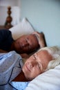 Senior white couple asleep in their bed, waist up, close up, vertical Royalty Free Stock Photo