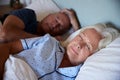 Senior white couple lying asleep in their bed, waist up, close up Royalty Free Stock Photo