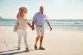 Senior white couple walking on a beach together holding hands, full length, close up Royalty Free Stock Photo