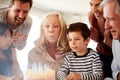 Senior white woman celebrating her birthday with family blowing out the candles on her cake Royalty Free Stock Photo