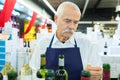 senior wine seller with bottle wine in wine house Royalty Free Stock Photo