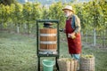 Senior winemaker with press machine on the vineyard