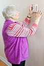 Senior woman adjusting her thermostat Royalty Free Stock Photo