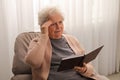 Senior woman with notebook at home. Age-related memory impairment