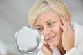 Senior woman applying anti-aging cream Royalty Free Stock Photo