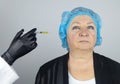 Botulinum toxin injection. Senior woman at the appointment with a beautician who is preparing to give anti-wrinkle injections. Royalty Free Stock Photo