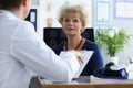 Senior woman on appointment in hospital listen to doctors prescription