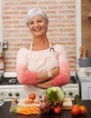 Senior woman or arms with knife in kitchen or confident, tomato or carrots for diet. Female chef in portrait with Royalty Free Stock Photo