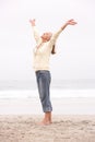 Senior Woman With Arms Outstretched On Beach Royalty Free Stock Photo