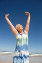 Senior woman with arms raised standing against clear sky Royalty Free Stock Photo