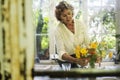 Senior woman arranging fresh flowers