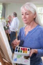 Senior Woman Attending Painting Class With Teacher In Background Royalty Free Stock Photo