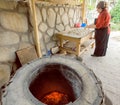 Senior woman baking pies in her home kitchen in Georgian village style with clay oven Royalty Free Stock Photo