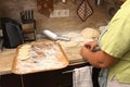 Senior woman baking pies in her home kitchen.Grandma cooks pies. Home cooked food. omemade mold cakes of the dough in Royalty Free Stock Photo