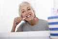 Senior Woman In Bathroom Brushing Teeth Royalty Free Stock Photo