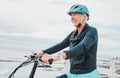 Senior woman, bike and smile in cycling by the beach for fun activity or travel in the city. Happy elderly woman smiling Royalty Free Stock Photo