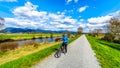 Senior woman biking along the Alouette River on the surrounding Pitt Polder at the town of Maple Ridge in British Columbia